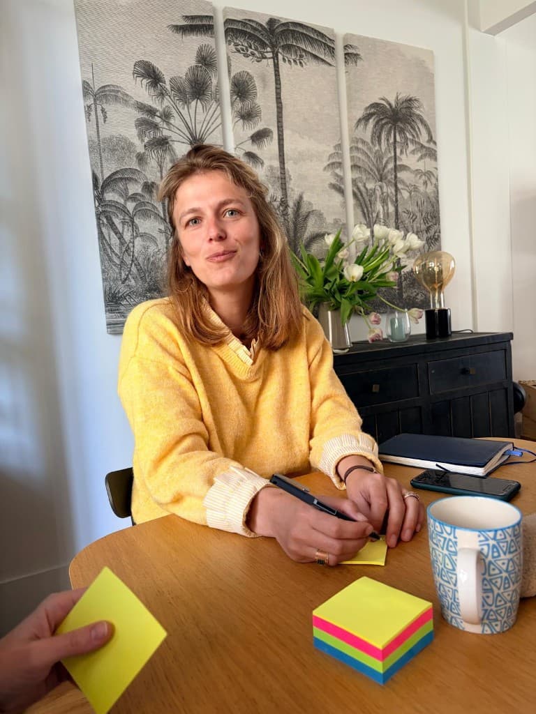Albane d'Harcourt en atelier, stylo en main devant des post-its colorés